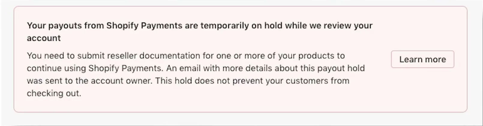 A pink Shopify admin banner reading Your payouts from Shopify Payments are temporarily on hold while we review your account, saying reseller documentation is needed and that the hold does not prevent customers from checking out, with a Learn more button